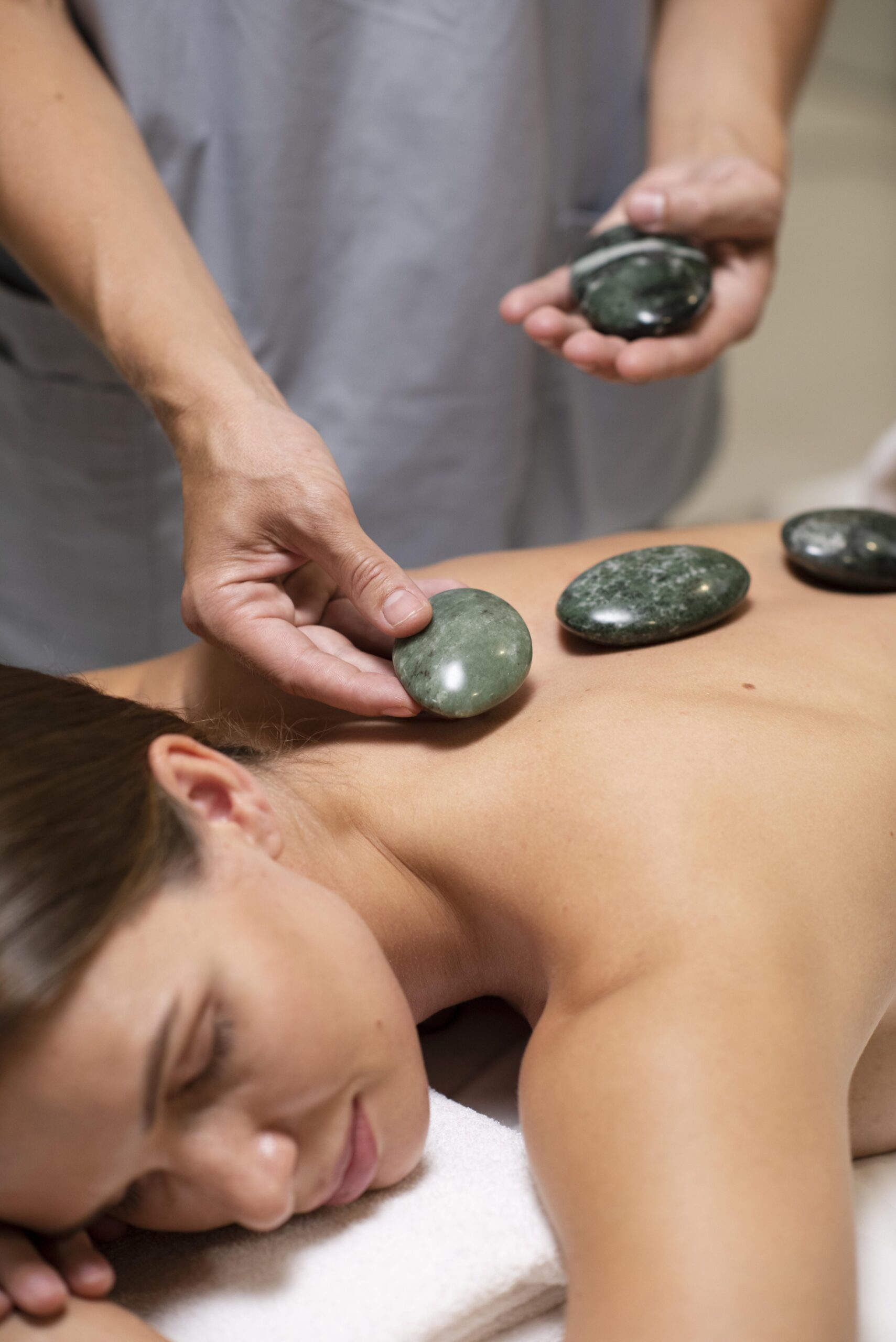 close up hands holding spa stones