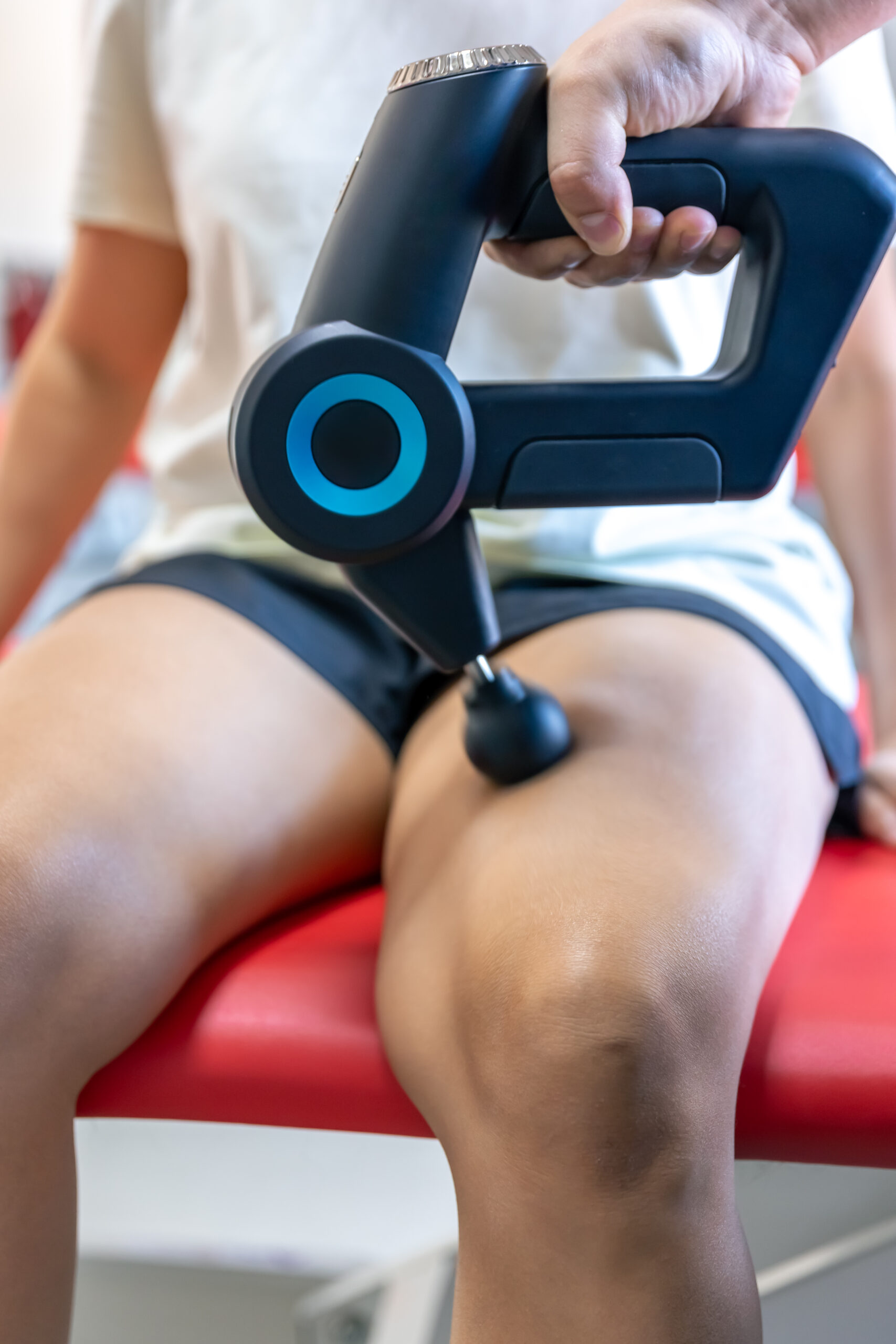 sports percussion massage in medical room of gym.